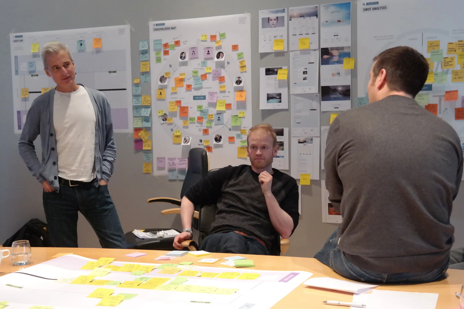 Participants comparing perspectives around a table covered with workshop materials