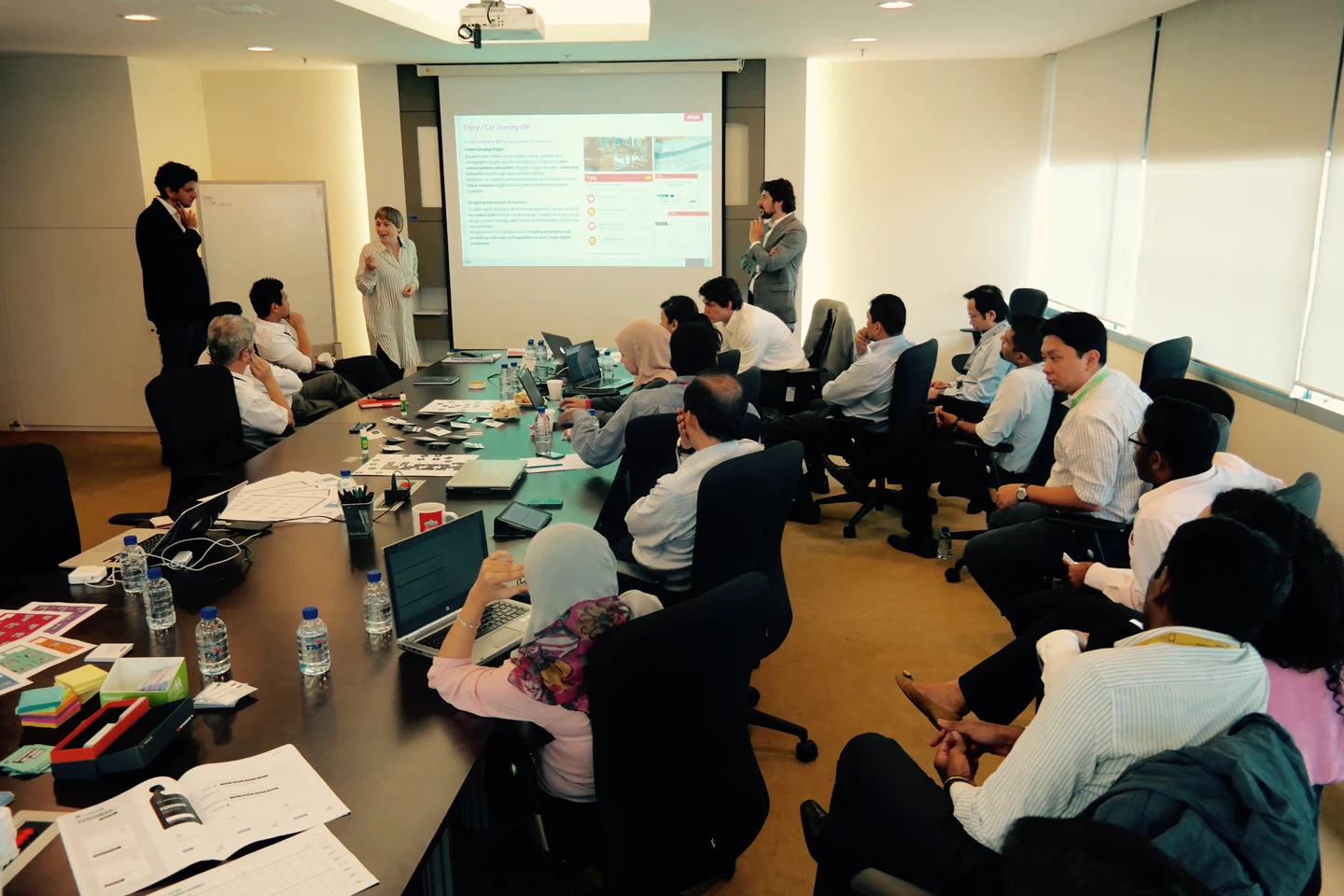 A workshop team discussing ideas around a table in Kuala Lumpur
