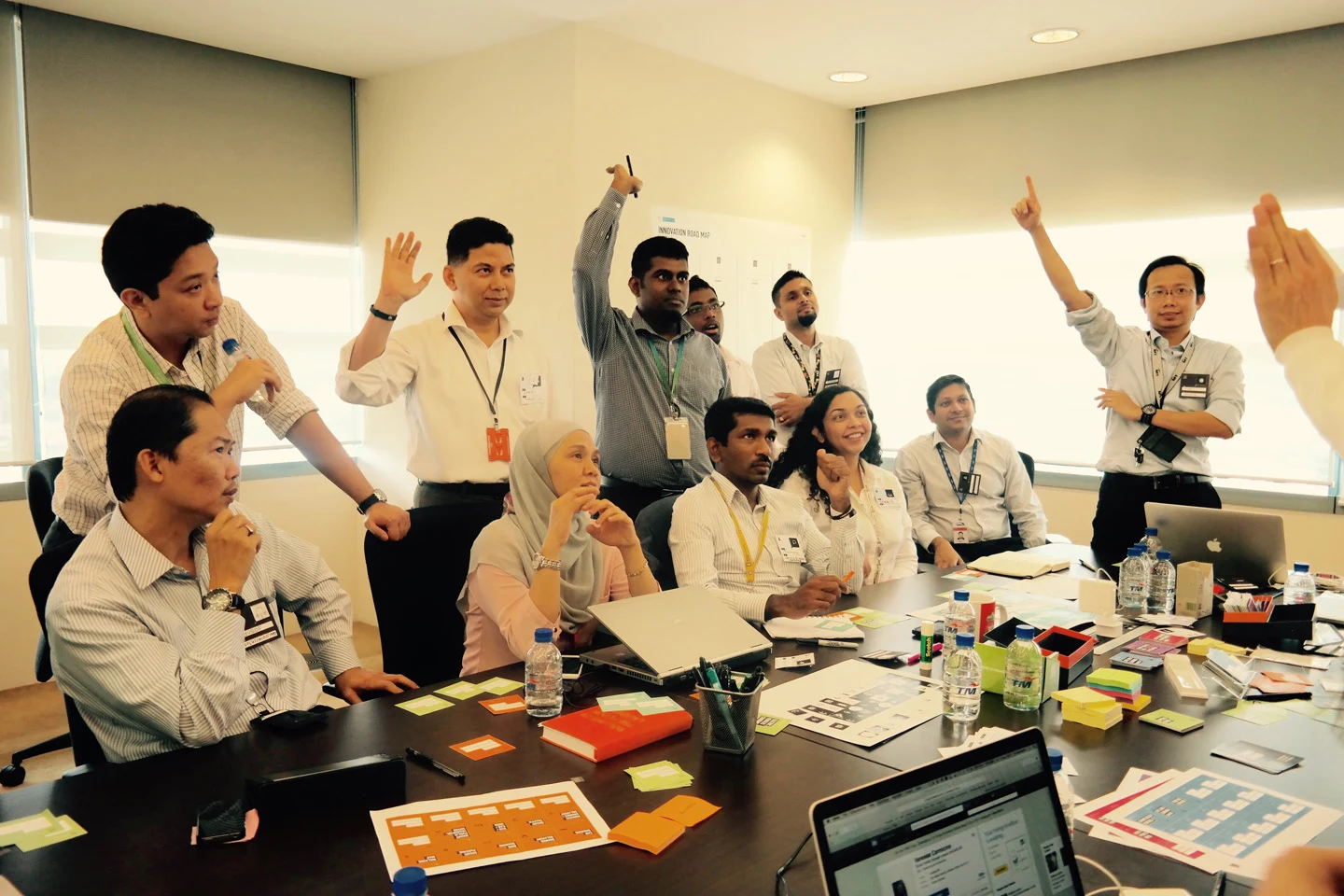 The workshop team raising hands during an interactive group exercise