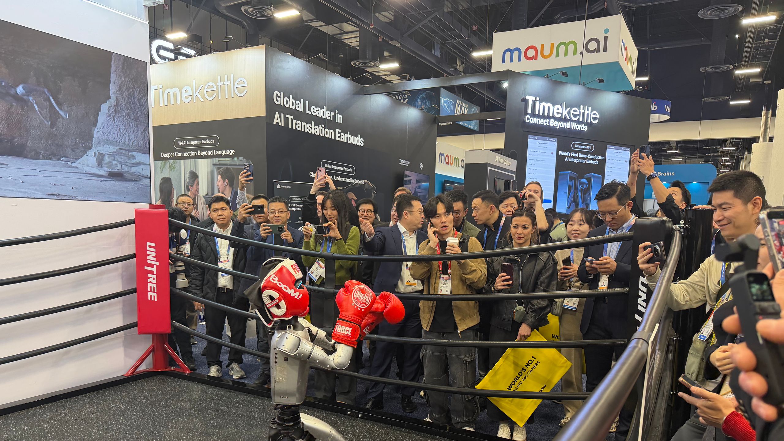 A humanoid robot wearing boxing gloves demonstrates its movements in front of a crowd